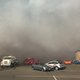Smoke from the Thunderhill fire looms over support vehicles and race cars. Photo credit: Will Faules